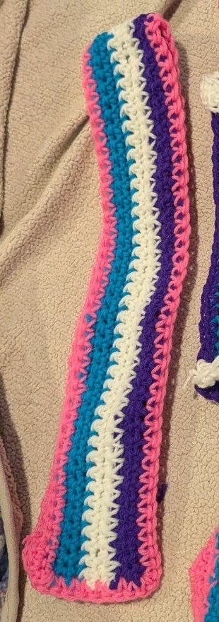 Teal, white, purple and pink striped crochet headband laid flat